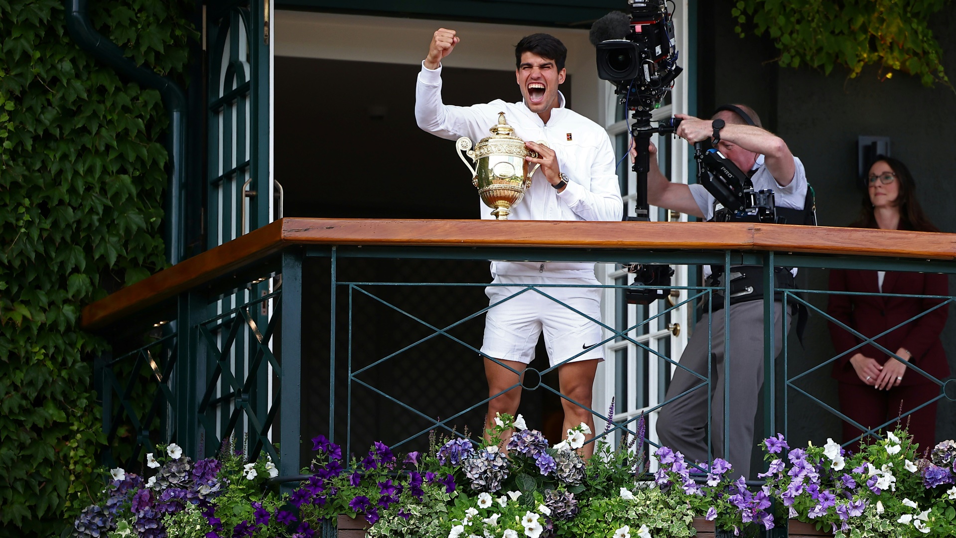 Carlos Alcaraz jubelt mit der Trophäe in Wimbledon