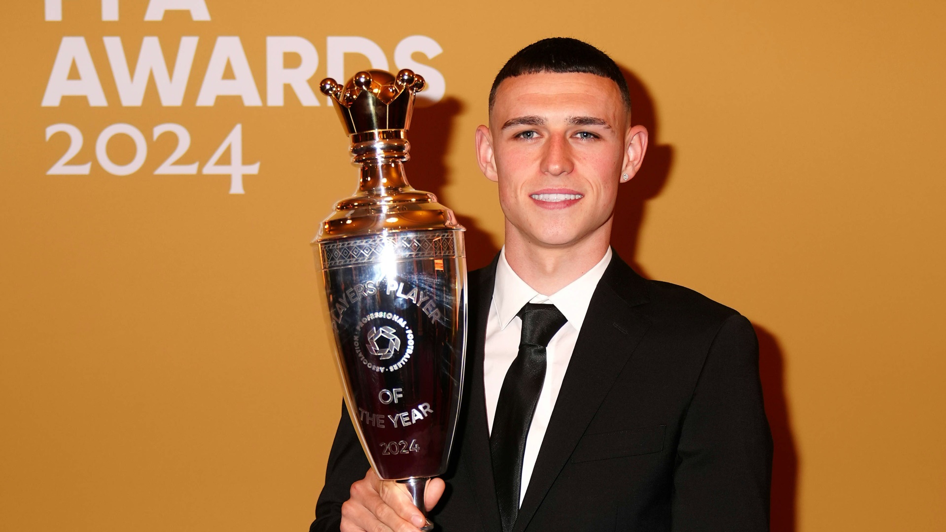 Phil Foden hält die PFA-Trophäe in den Händen