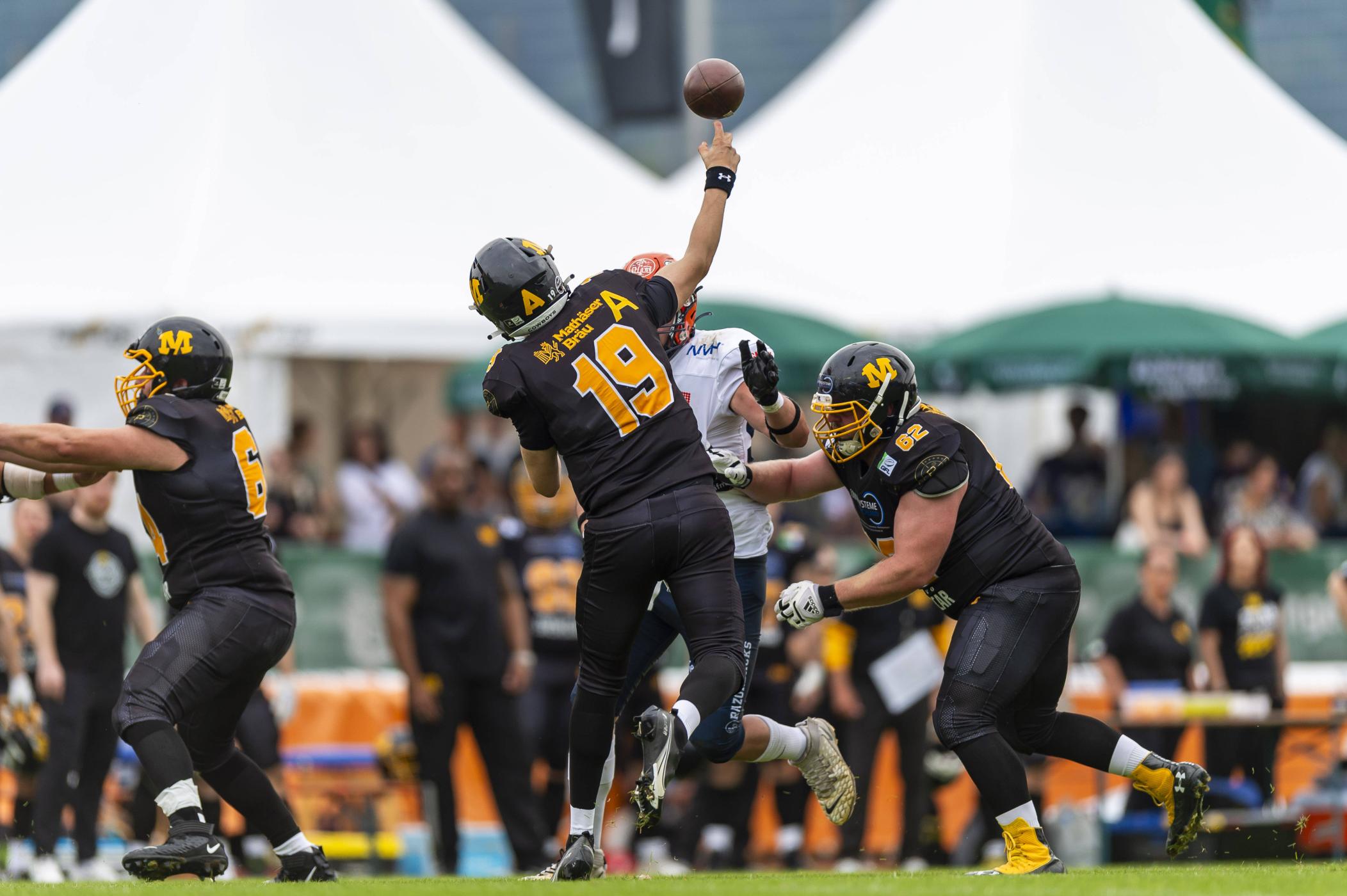 Eine Spielszene aus dem Spiel der Munich Cowboys gegen die Ravensburg Razorbacks. Im Vordergrund Quarterback Nicklas Yockey bei einem Wurf.